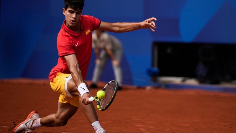 Spain's Carlos Alcaraz backhands to Serbia's Novak Djokovic during the...