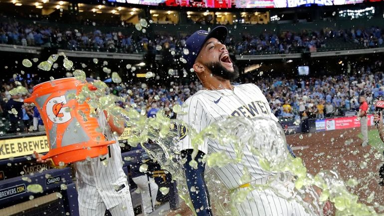 Milwaukee Brewers' Devin Williams, right, gets doused with liquid by...