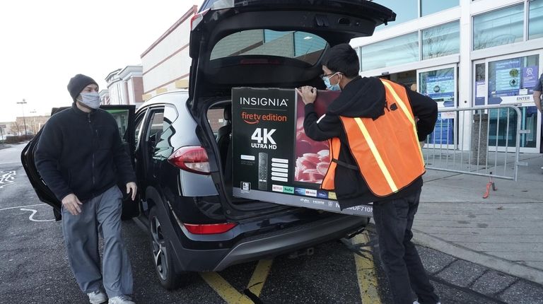 A Best Buy customer gets curbside delivery at the store in...