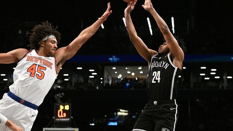 Nets guard Cam Thomas shoots past Knicks center Jericho Sims...