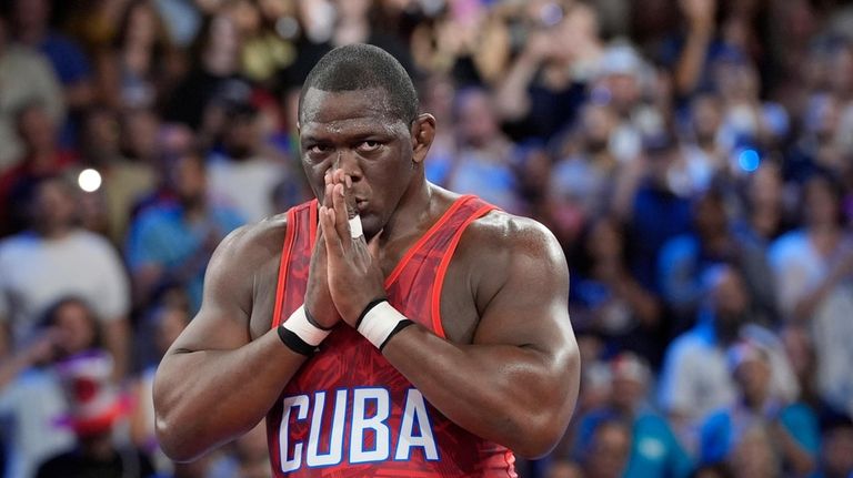 Cuba's Mijain Lopez Nunez celebrates after defeating Chile's Yasmani Acosta...