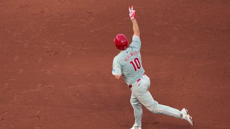 Philadelphia Phillies' J.T. Realmuto celebrates as he runs the bases...