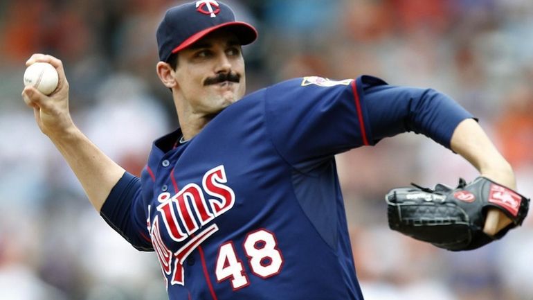 Minnesota Twins starter Carl Pavano (48) throws a pitch during...