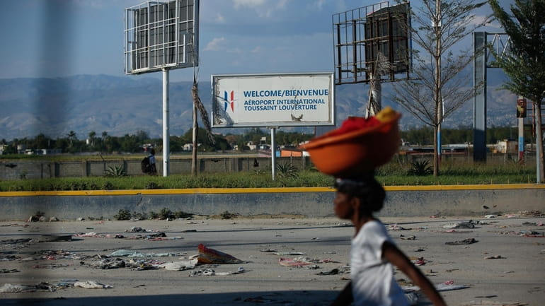 A pedestrian walks past the international airport in Port-au-Prince, Haiti,...