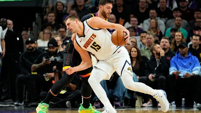 Denver Nuggets center Nikola Jokic (15) backs down Phoenix Suns...