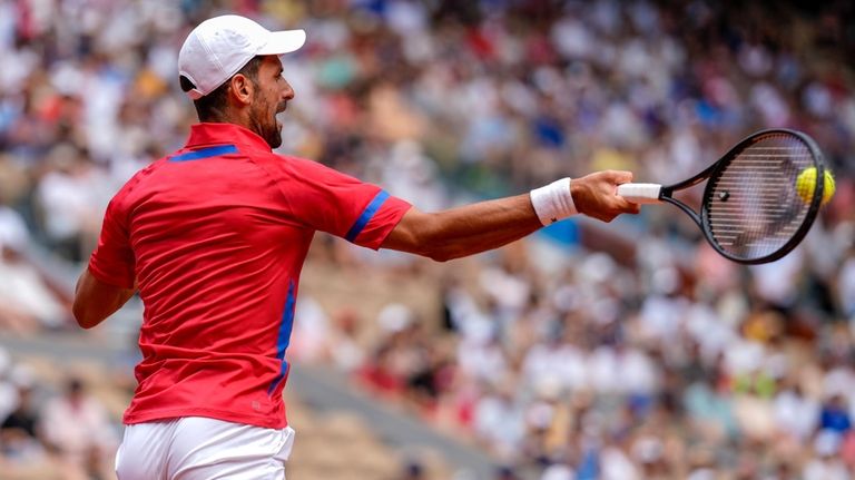 Serbia's Novak Djokovic returns the ball against Germany's Dominik Koepfer...