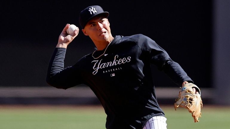 Anthony Volpe of the New York Yankees warms up on...