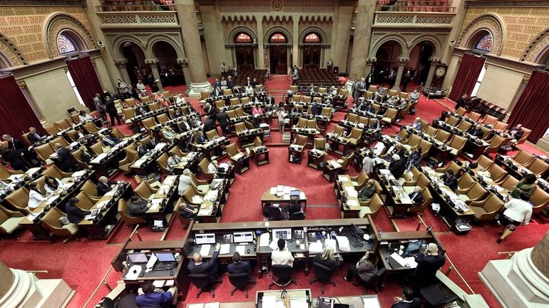 New York State Assembly members work on passing legislation in...