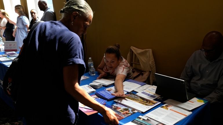 A woman shows different pamphlets at the Black Health Matters...