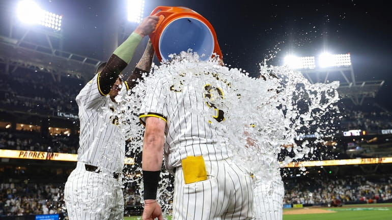 San Diego Padres' Jake Cronenworth, foreground, is doused after his...