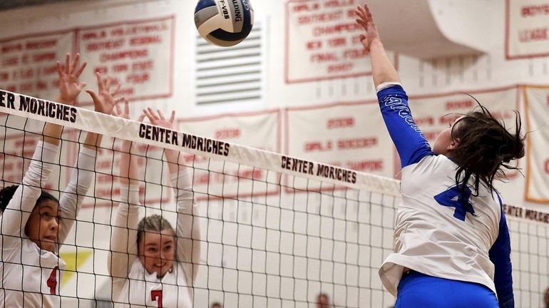 Hauppauge middle Alison Tsororos goes for the kill shot against...