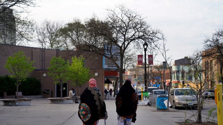 Women walk down a street in the predominantly Somali neighborhood...