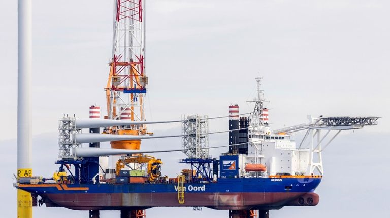 A barge carries blades for the third turbine at the...