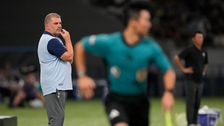 Tottenham's head coach Ange Postecoglou, left, watches play during the...