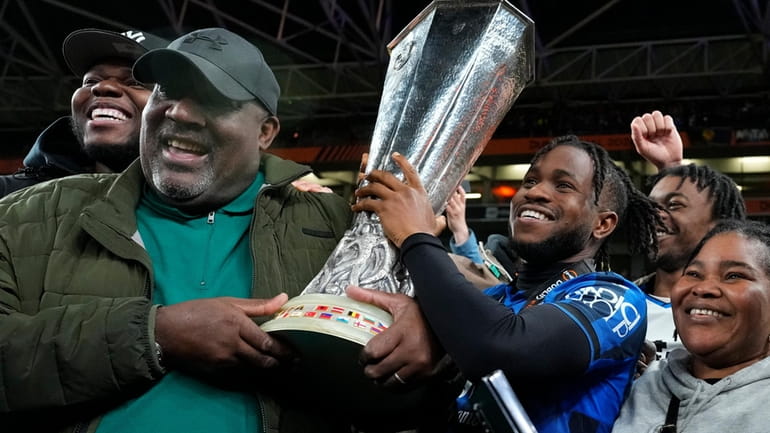 Atalanta's Ademola Lookman celebrates with family members holding the trophy...