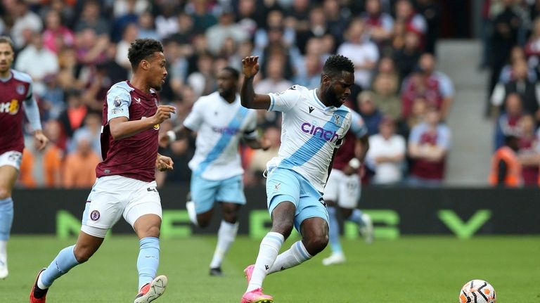 Aston Villa's Ezri Konsa, left, and Crystal Palace's Jeffrey Schlupp...