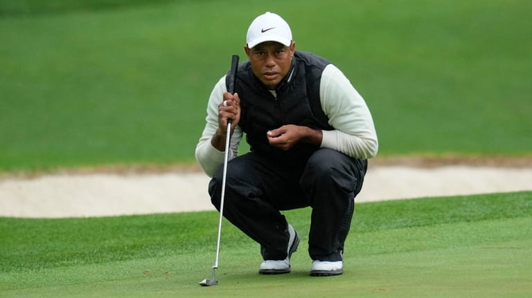 Tiger Woods lines up a putt on the 16th hole...