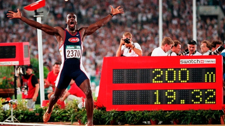 Michael Johnson, of the United States, celebrates after he won...