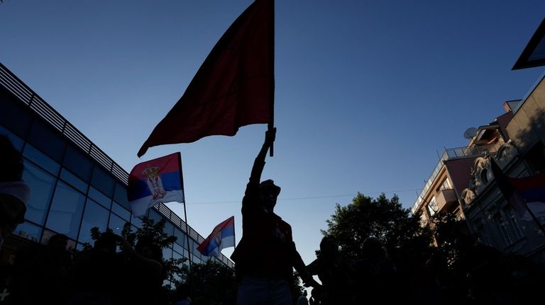 A man holds an old Yugoslav Communists' flag during a...