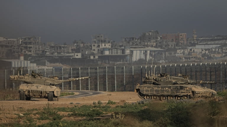 Israeli tanks stand near the Israel-Gaza border as seen from...