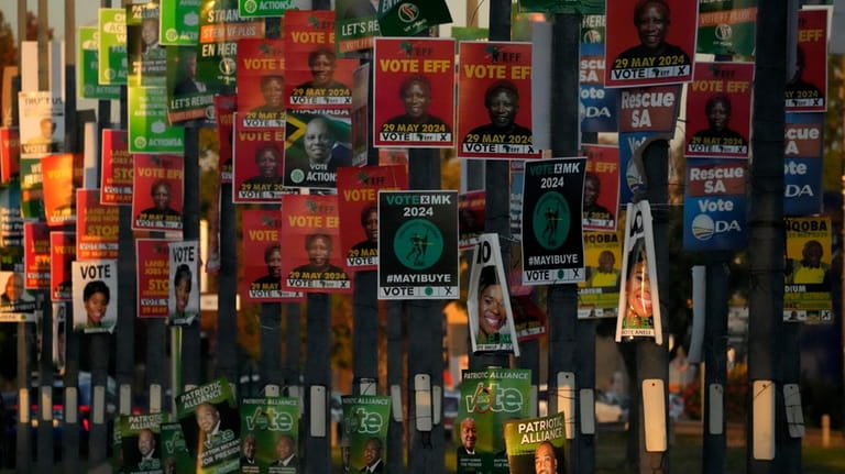 An array of election posters from various political parties are...