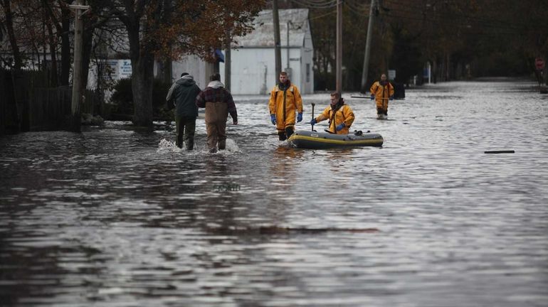 Firefighters walk through flooding at Main Street and Degnon Boulevard...