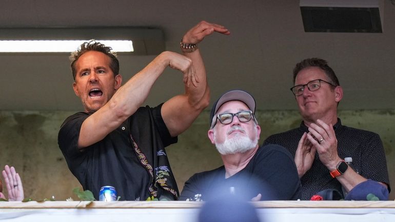 Wrexham co-owner, actor Ryan Reynolds, left, acknowledges the crowd while...