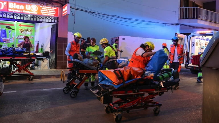 Medics take injured people away from a building that collapsed...