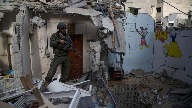 An Israeli soldier stands at the entrance of a tunnel...