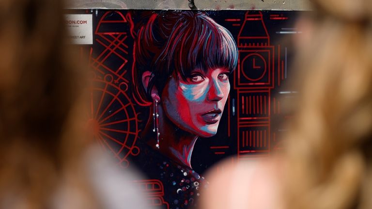 People look at a new mural portrait of Taylor Swift...