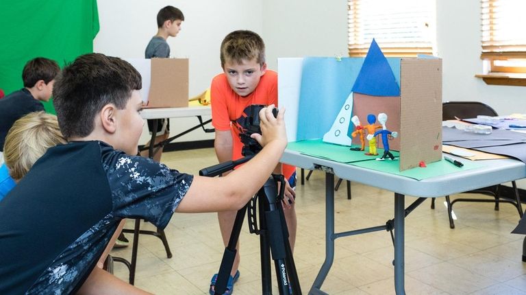 Gerry Caramore, 9, of Aquebogue, center, directs Jack Bartolo, 9, of...