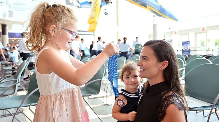 Penelope Acierno, 6, places a medal on her mother, Army...