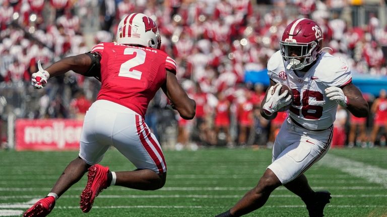 Alabama's Jam Miller (26) gets past Wisconsin's Ricardo Hallman (2)...