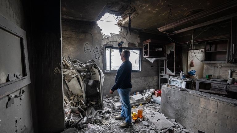 Hussein Fawaz inspects damages to his family house that was...