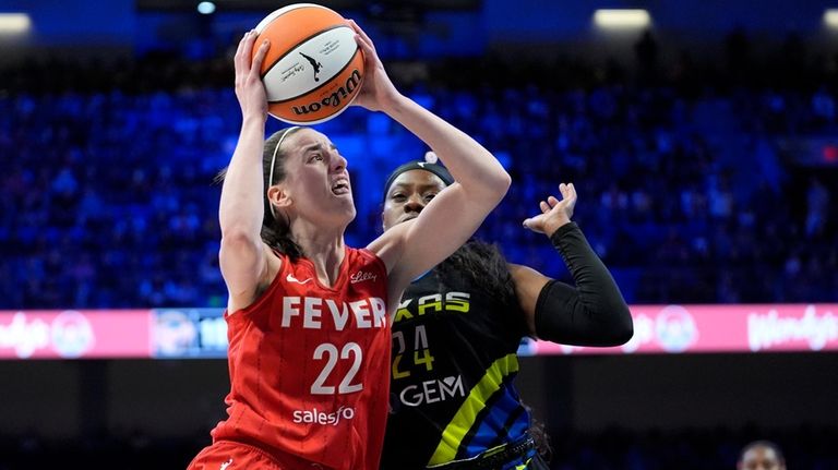 Indiana Fever guard Caitlin Clark (22) leaps to the basket...