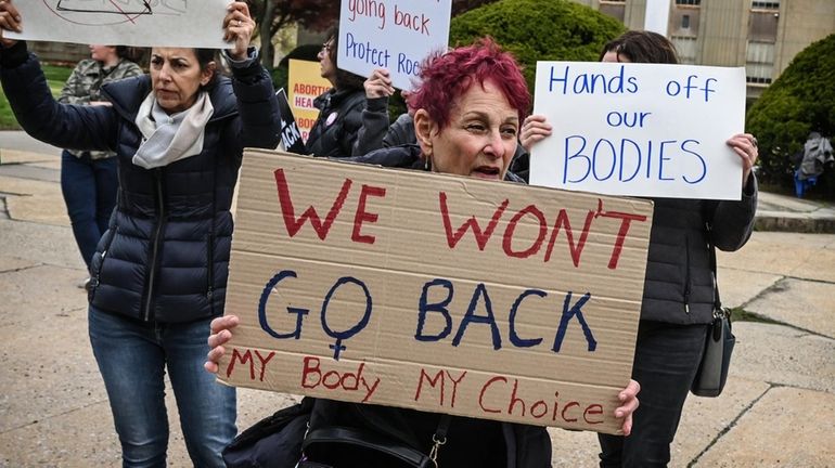 Judi Gardner of Melville, (center) protests against the leaked US...