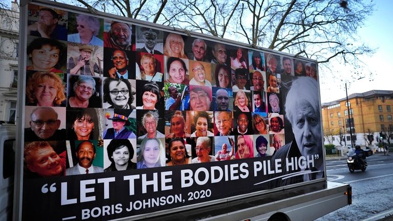 A van displaying a protest banner is parked outside the...