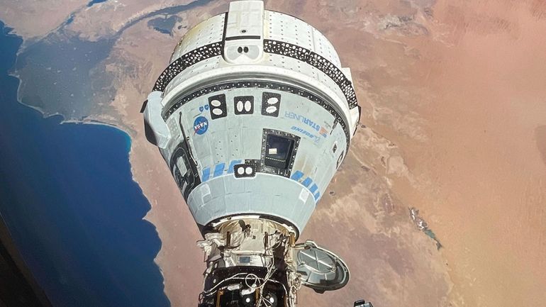 This photo provided by NASA shows the Starliner spacecraft docked...