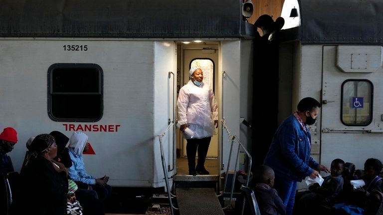 A healthcare worker stands at the door of the Phelophepa...