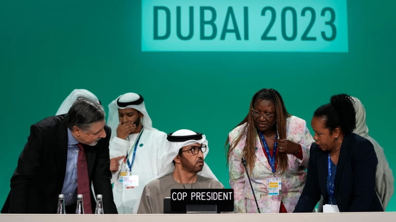 COP28 President Sultan al-Jaber, center, and COP28 CEO Adnan Amin...