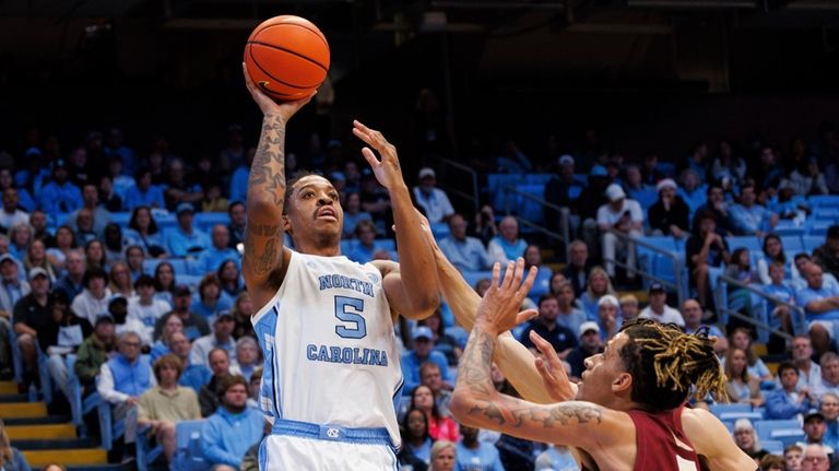 North Carolina's Armando Bacot, left, attempts a shot over Florida...