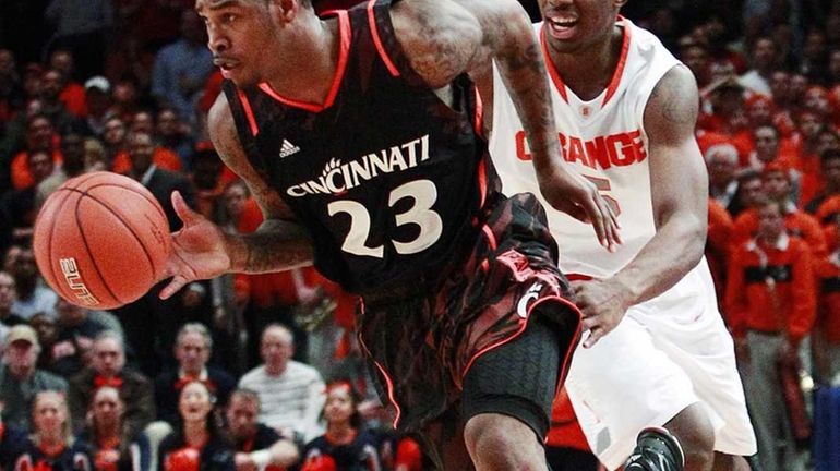 Cincinnati's Sean Kilpatrick (23) drives past Syracuse's C.J. Fair (5)...