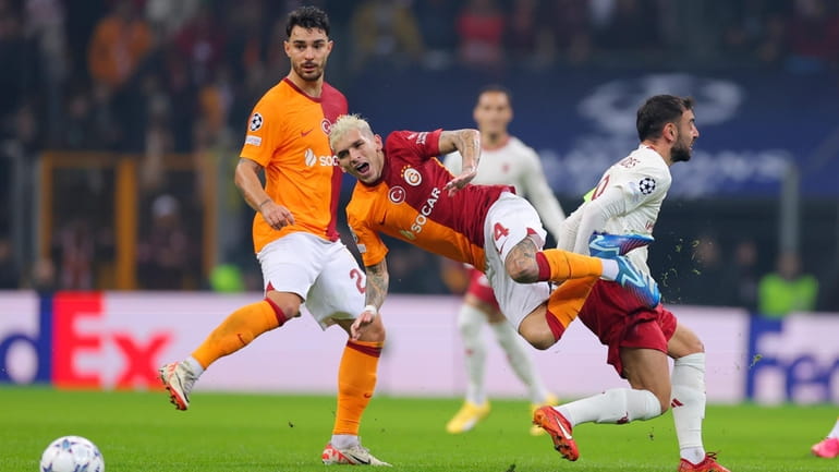 Galatasaray's Wilfried Zaha, centre, challenges for the ball with Manchester...