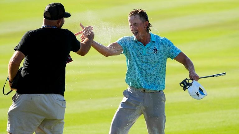 Jake Knapp, of the United States, right, celebrates on the...