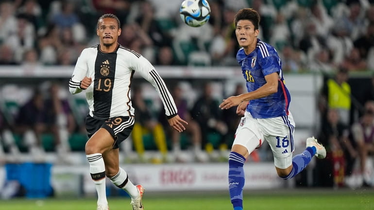 Germany's Leroy Sane, left, vie for the ball with Japan's...