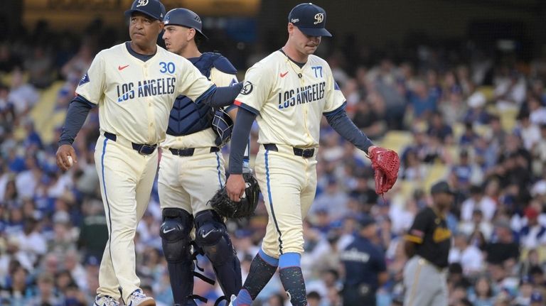 Los Angeles Dodgers' Austin Barnes, center, looks on as manager...