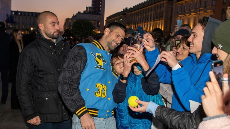 Serbia's Novak Djokovic takes a selfie with fans during the...