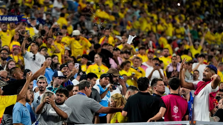 Uruguay's Ronald Araujo, right, argues with fans at the end...
