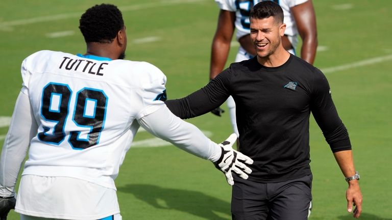 Carolina Panthers head coach Dave Canales, right, greets defensive tackle...