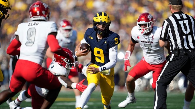 Michigan quarterback J.J. McCarthy (9) runs the ball against UNLV...